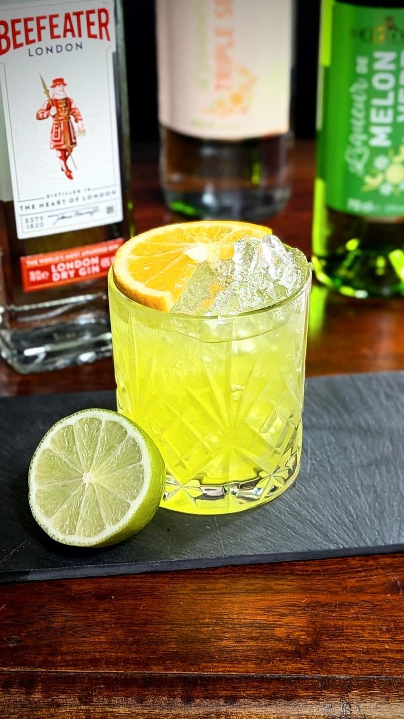 Cocktail vert gin et liqueur de melon, rondelle d’orange