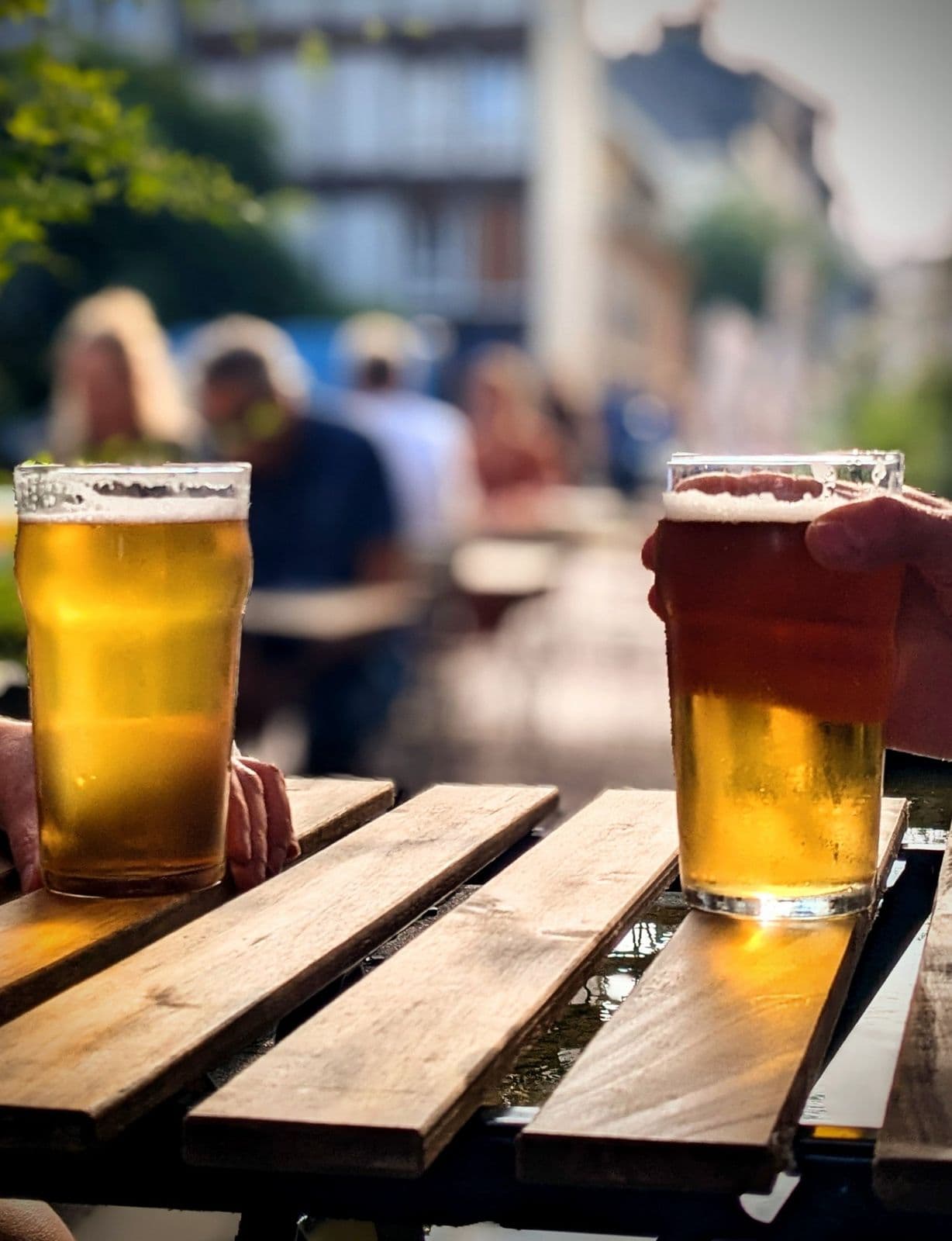 Deux pintes de blonde posées sur une table de terrasse au soleil
